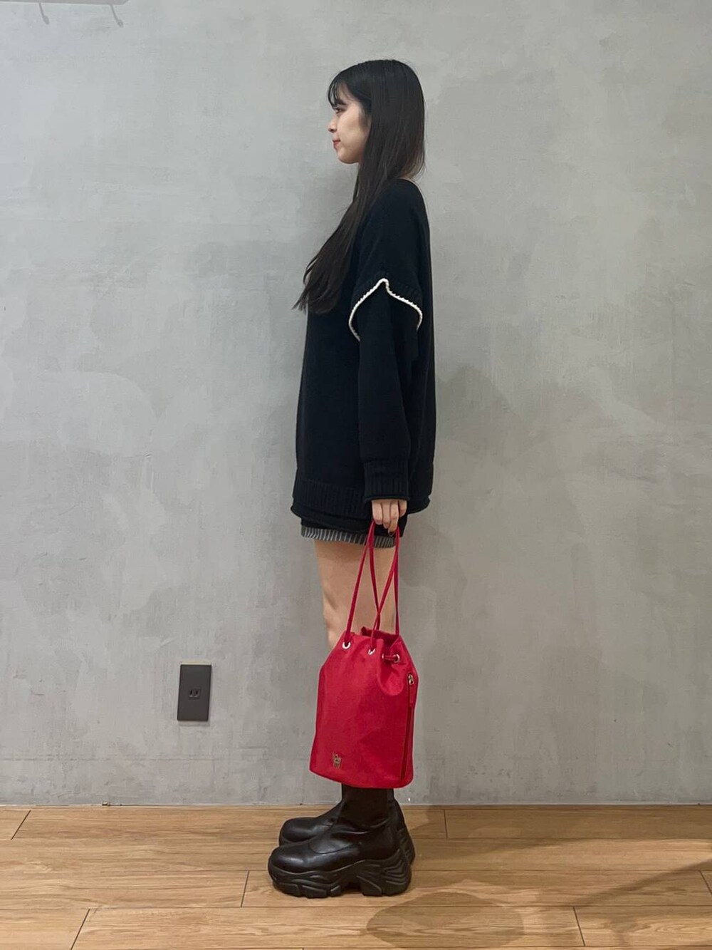 ブラック系のニット/セーター、ブルー系のその他パンツ、ブラック系のブーツを着用したレディースの秋コーディネートの2枚目の写真