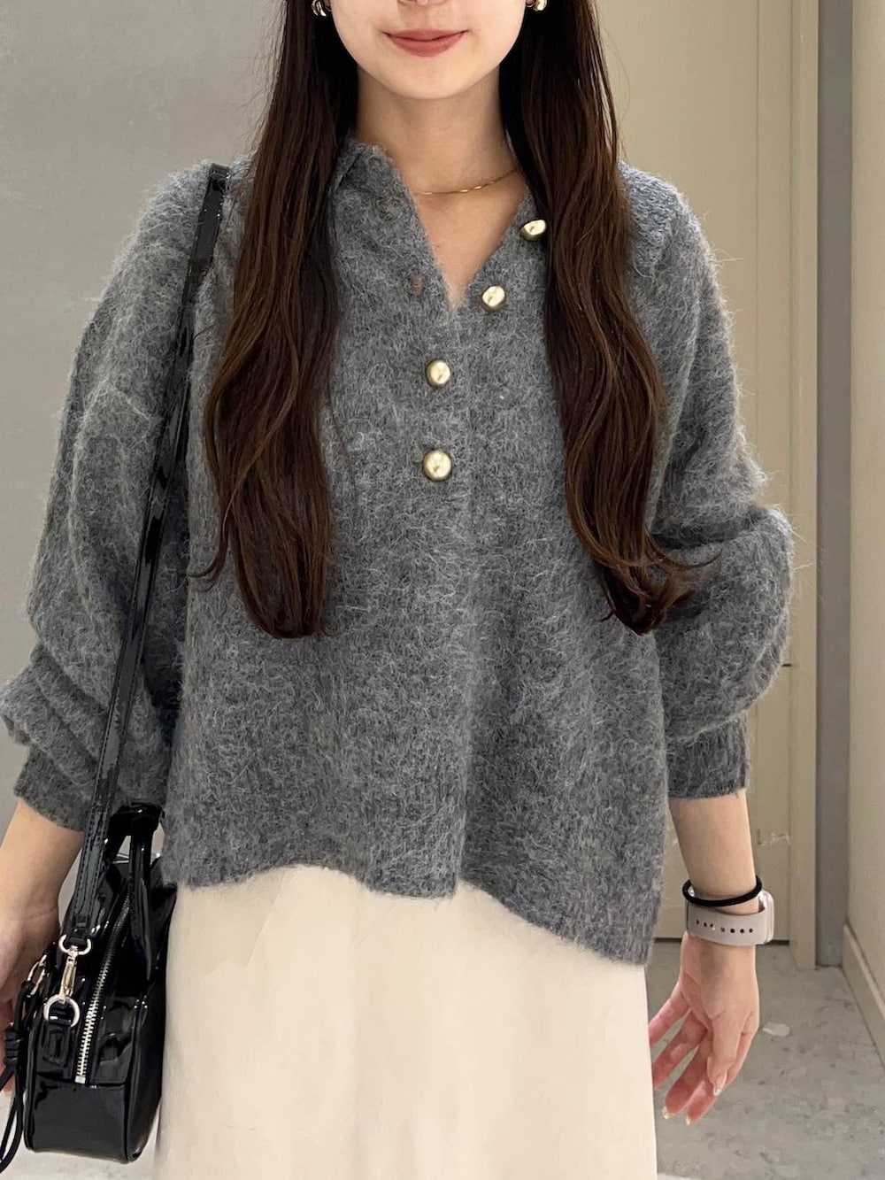 ホワイト系のスカート、ブラック系のパンプス、ブラック系のボストンバッグを着用したレディースの秋コーディネートの4枚目の写真