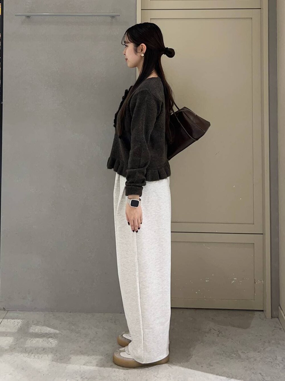 グレー系のスウェットパンツ、ブラウン系のニット/セーター、ブラウン系のボストンバッグを着用したレディースの冬コーディネートの3枚目の写真