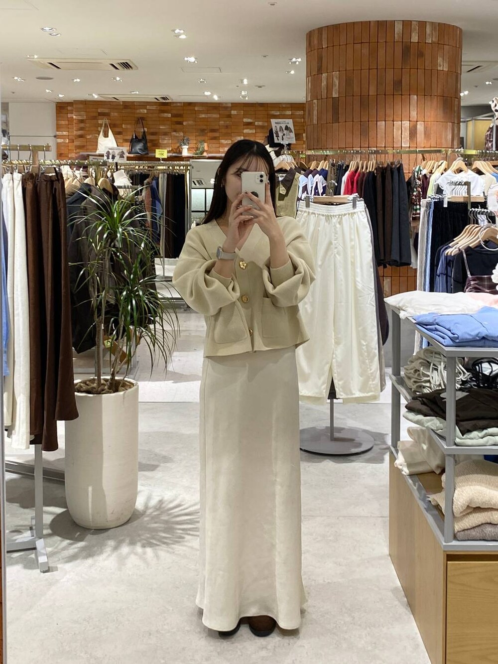 ホワイト系のスカート、ホワイト系のカーディガン/ボレロ、ブラウン系のローファーを着用したレディースの秋コーディネートの2枚目の写真