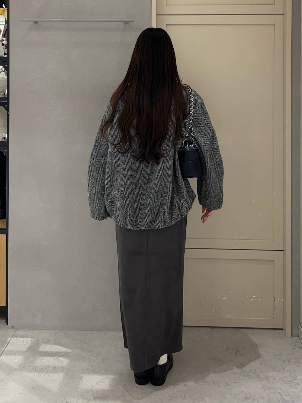 ブラック系のニット/セーター、グレー系のブルゾン、グレー系のスカートを着用したレディースの秋コーディネートの4枚目の写真