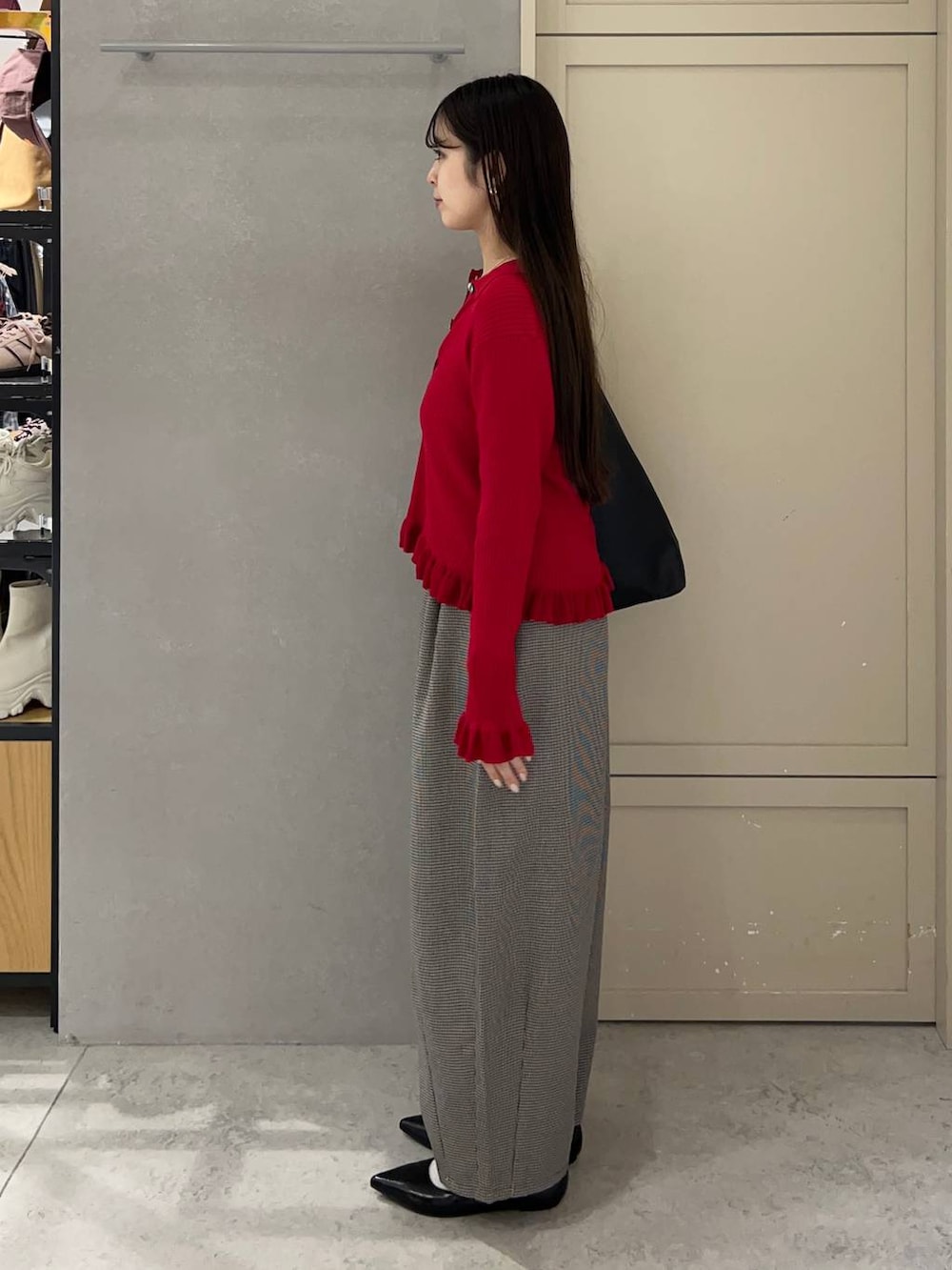 ブラック系のショルダーバッグ、ブラック系のパンプス、レッド系のニット/セーターを着用したレディースの秋コーディネートの3枚目の写真