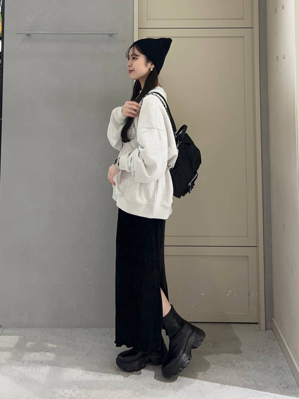 ブラック系のブーツ、ブラック系のスカート、ブラック系のショルダーバッグを着用したレディースの冬コーディネートの3枚目の写真