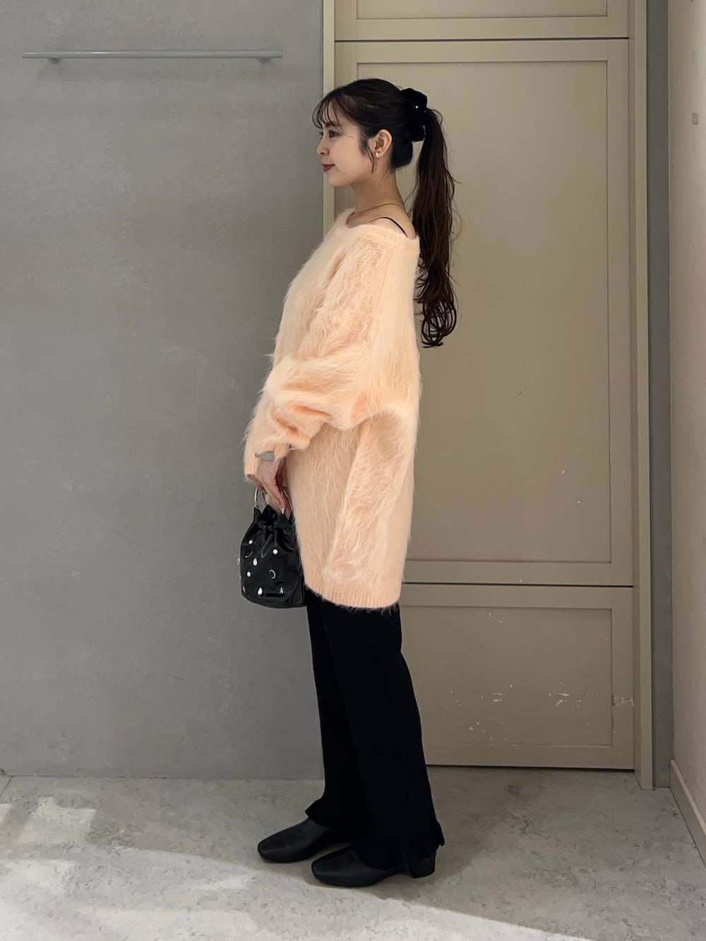 ブラック系のその他パンツ、ブラック系のブーツ、ピンク系のニット/セーターを着用したレディースの春コーディネートの2枚目の写真