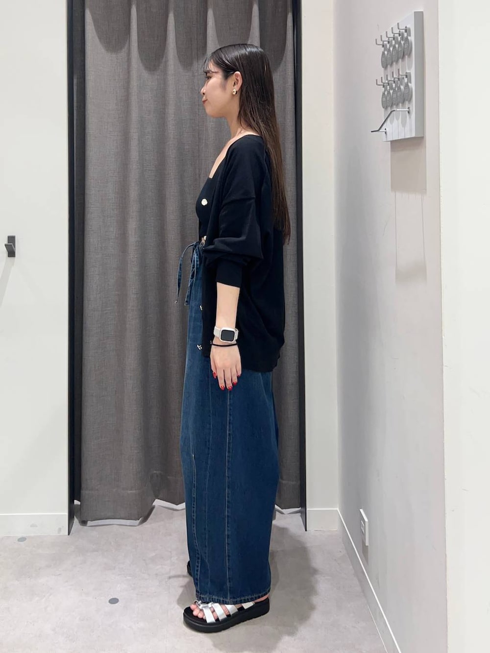 ブラック系のキャミソール、ブルー系のデニムパンツ、シルバー系のサンダルを着用したレディースの夏コーディネートの3枚目の写真