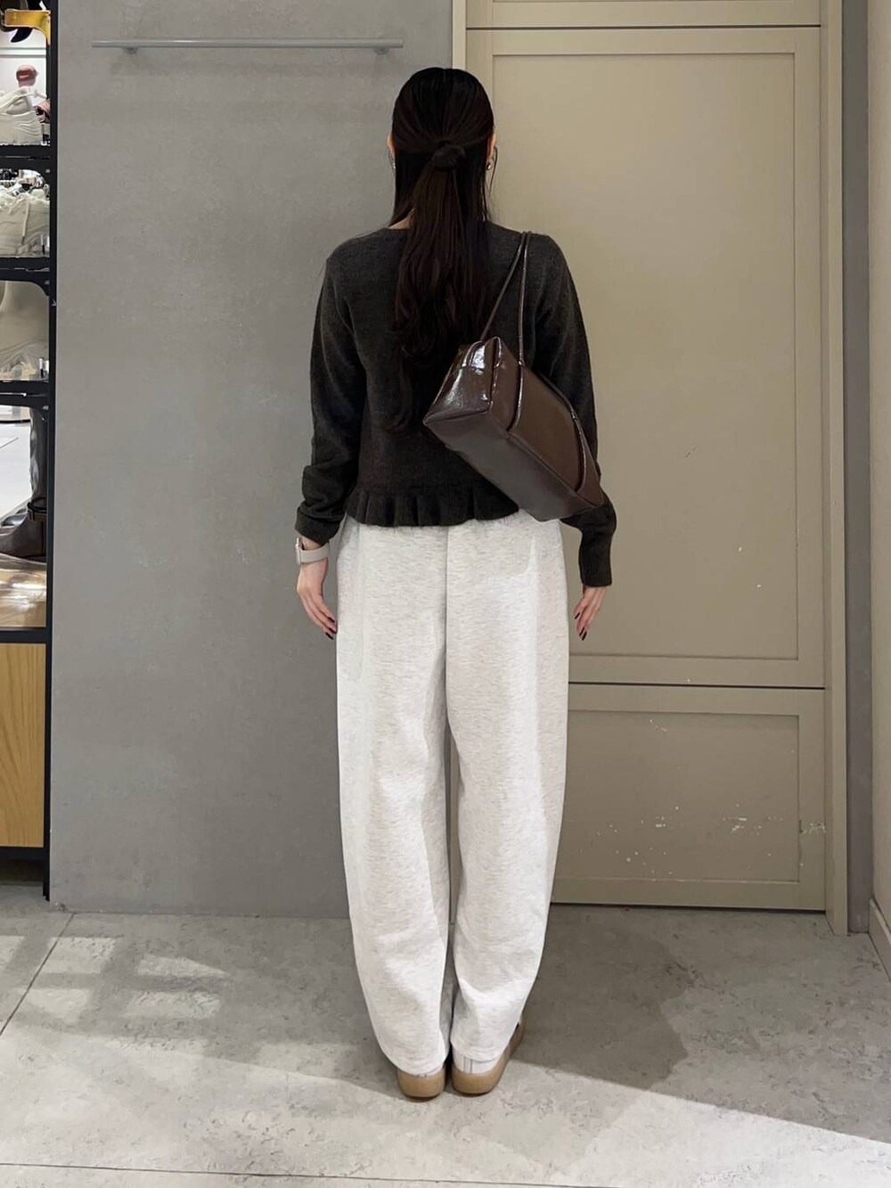 グレー系のスウェットパンツ、ブラウン系のニット/セーター、ブラウン系のボストンバッグを着用したレディースの冬コーディネートの4枚目の写真