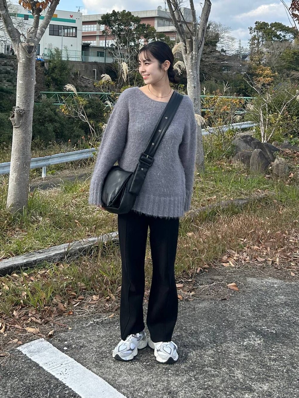 グレー系のニット/セーター、ブラック系のその他パンツ、ゴールド系のチョーカーを着用したレディースの冬コーディネートの2枚目の写真