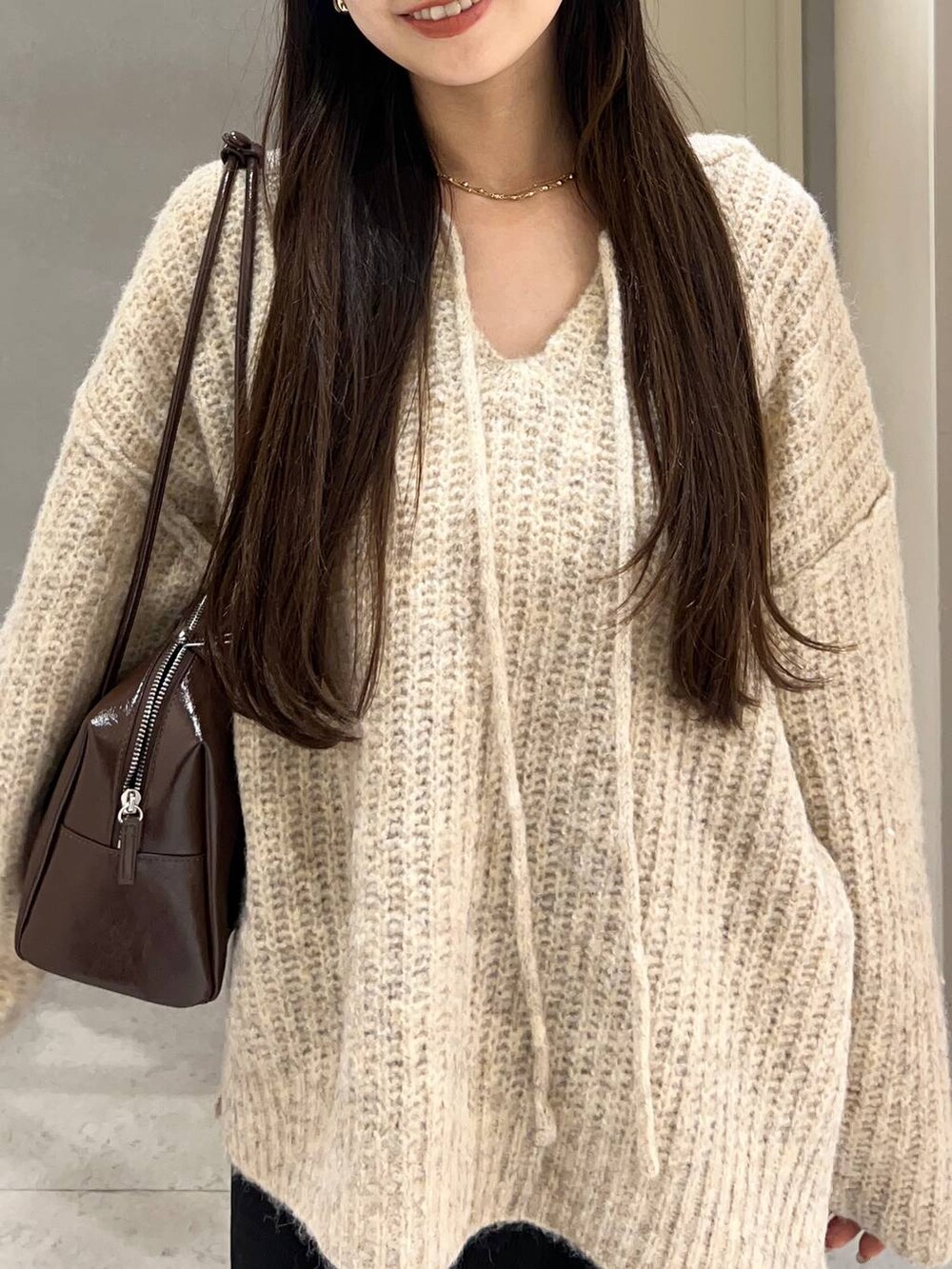 ホワイト系のニット/セーター、ブラック系のその他パンツ、ブラウン系のローファーを着用したレディースの秋コーディネートの5枚目の写真