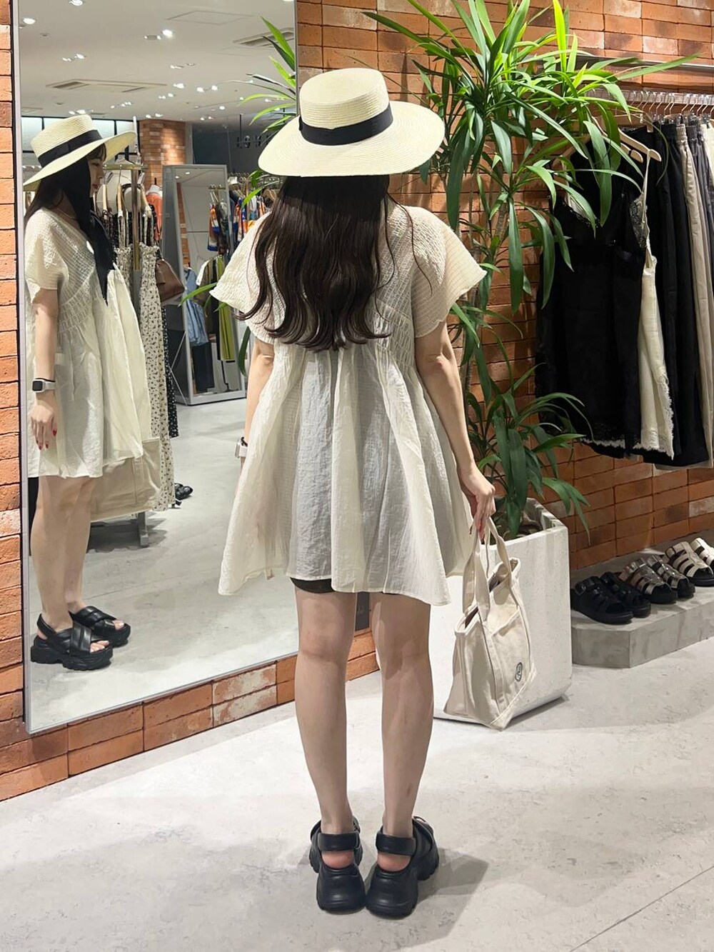 ブラック系のキャミソール、ブラウン系のその他パンツ、ホワイト系のショルダーバッグを着用したレディースの夏コーディネートの2枚目の写真