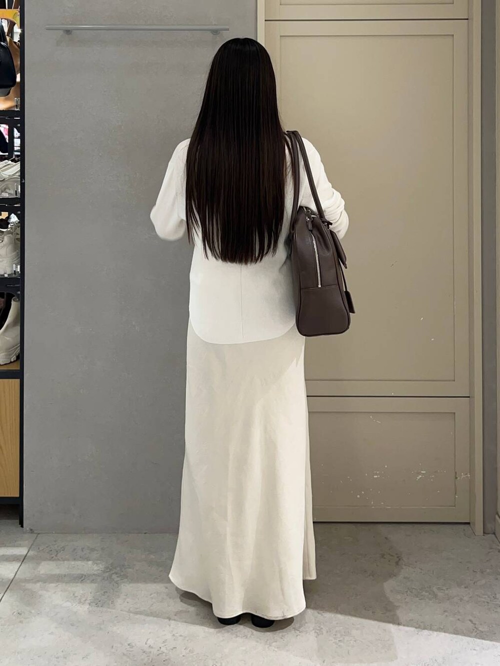 ホワイト系のスカート、ブラウン系のショルダーバッグ、ブラウン系のローファーを着用したレディースの秋コーディネートの3枚目の写真