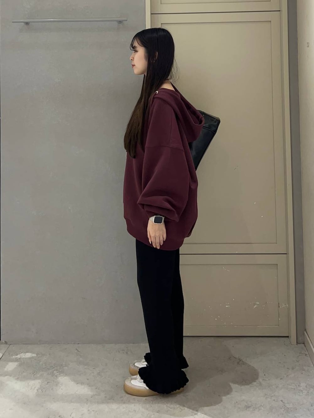 レッド系のパーカー、ブラック系のその他パンツ、ブラック系のボストンバッグを着用したレディースの秋コーディネートの3枚目の写真