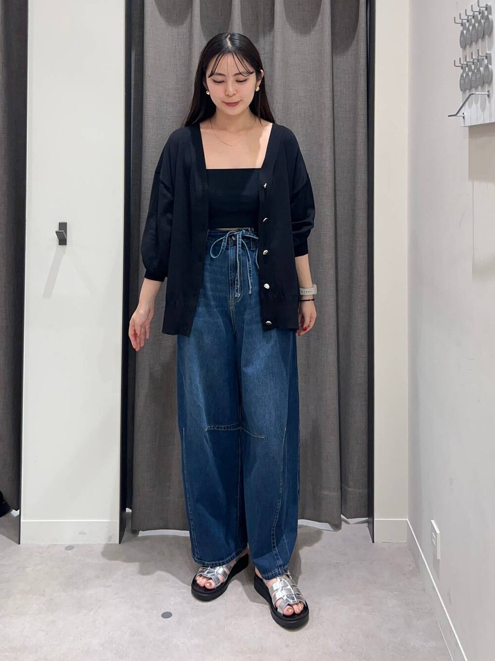 ブラック系のキャミソール、ブルー系のデニムパンツ、シルバー系のサンダルを着用したレディースの夏コーディネートの2枚目の写真