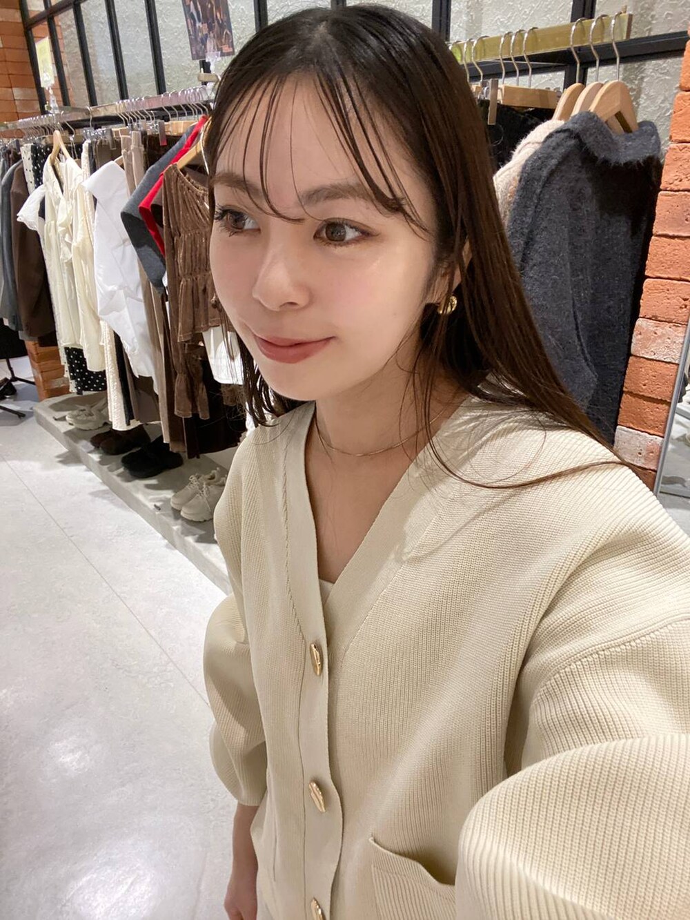 ホワイト系のスカート、ホワイト系のカーディガン/ボレロ、ブラウン系のローファーを着用したレディースの秋コーディネートの4枚目の写真