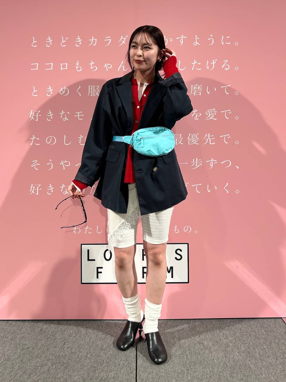 ブルー系のボディバッグ/ウエストポーチ、ブラック系のサンダル、ホワイト系のTシャツ/カットソーを着用したレディースの春コーディネートの3枚目の写真