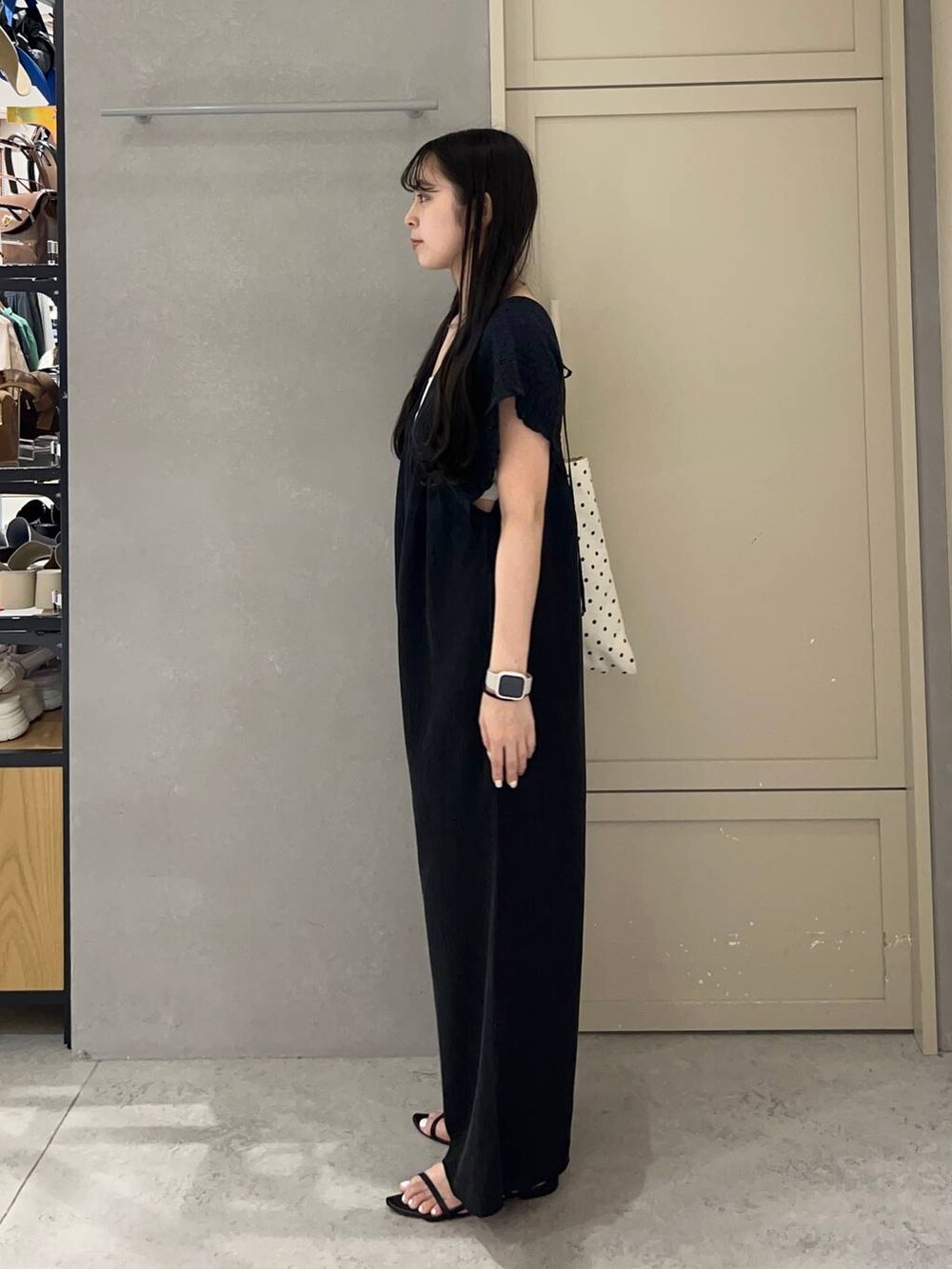 ホワイト系のキャミソール、その他のトートバッグ、ブラック系のサンダルを着用したレディースの夏コーディネートの3枚目の写真