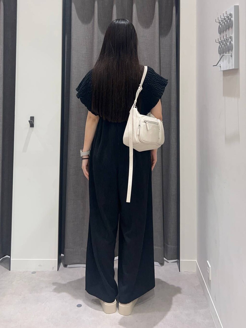 ブラック系のキャミソール、ホワイト系のサンダル、ブラック系のサロペット/オーバーオールを着用したレディースの夏コーディネートの4枚目の写真