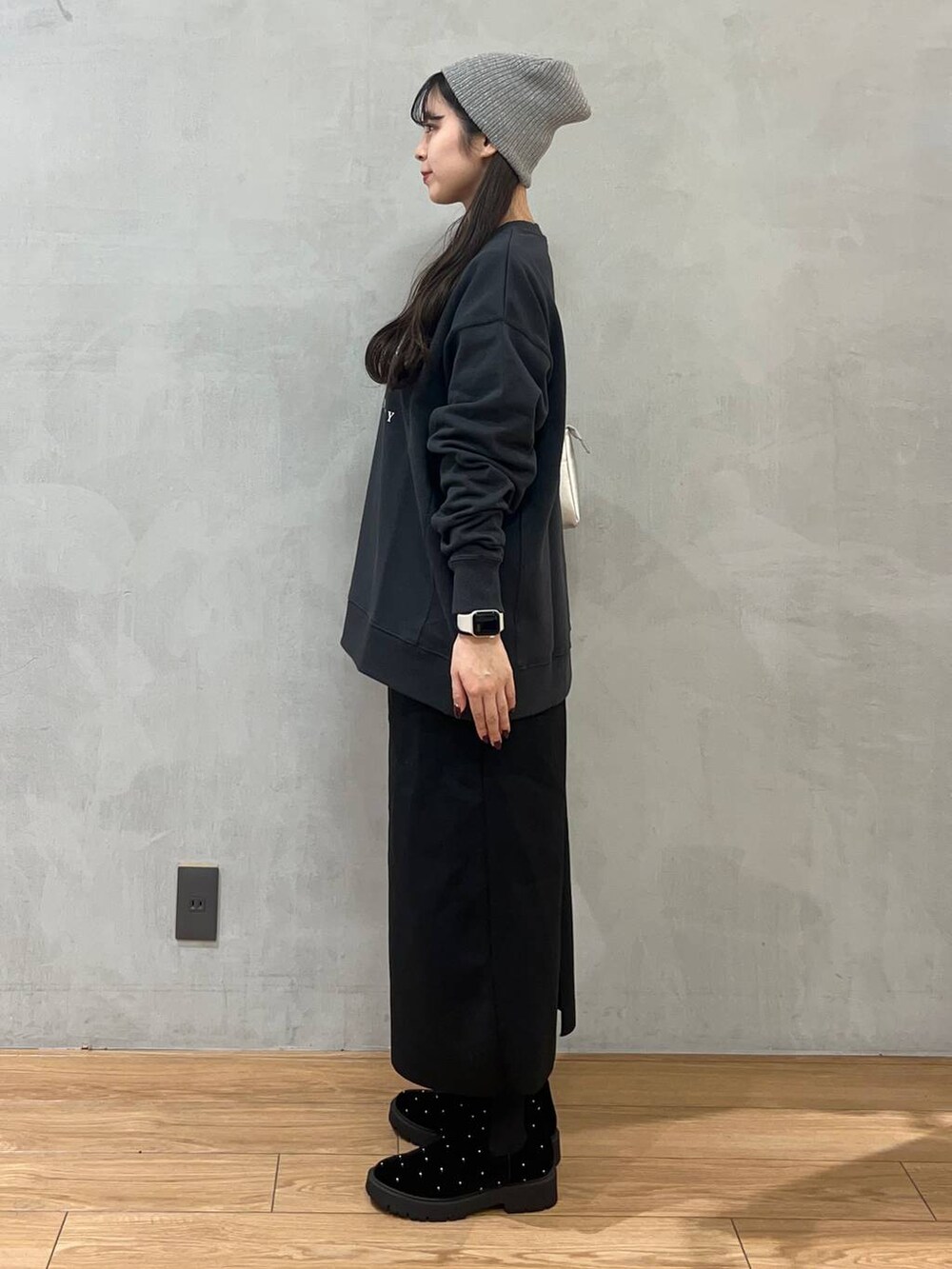 ブラック系のスカート、グレー系のスウェット、シルバー系のショルダーバッグを着用したレディースの秋コーディネートの2枚目の写真