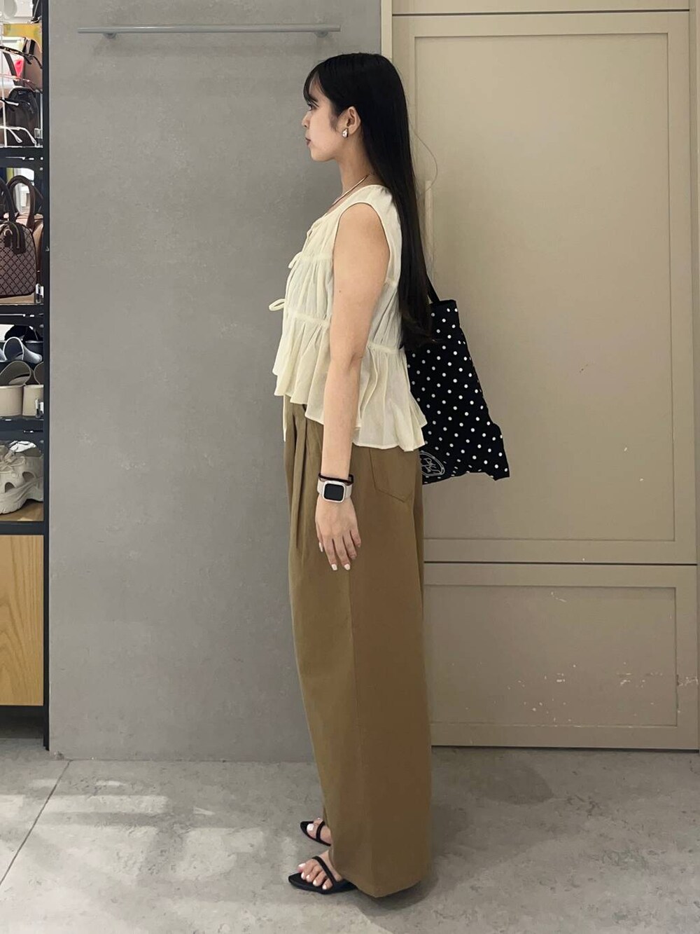 ブラック系のキャミソール、その他のトートバッグ、ブラック系のサンダルを着用したレディースの夏コーディネートの3枚目の写真