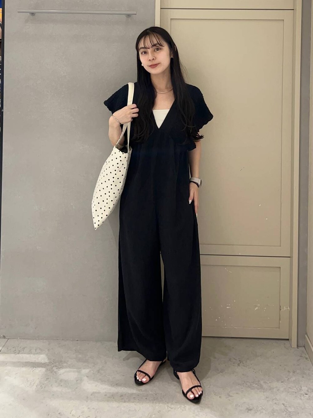 ホワイト系のキャミソール、その他のトートバッグ、ブラック系のサンダルを着用したレディースの夏コーディネートの2枚目の写真