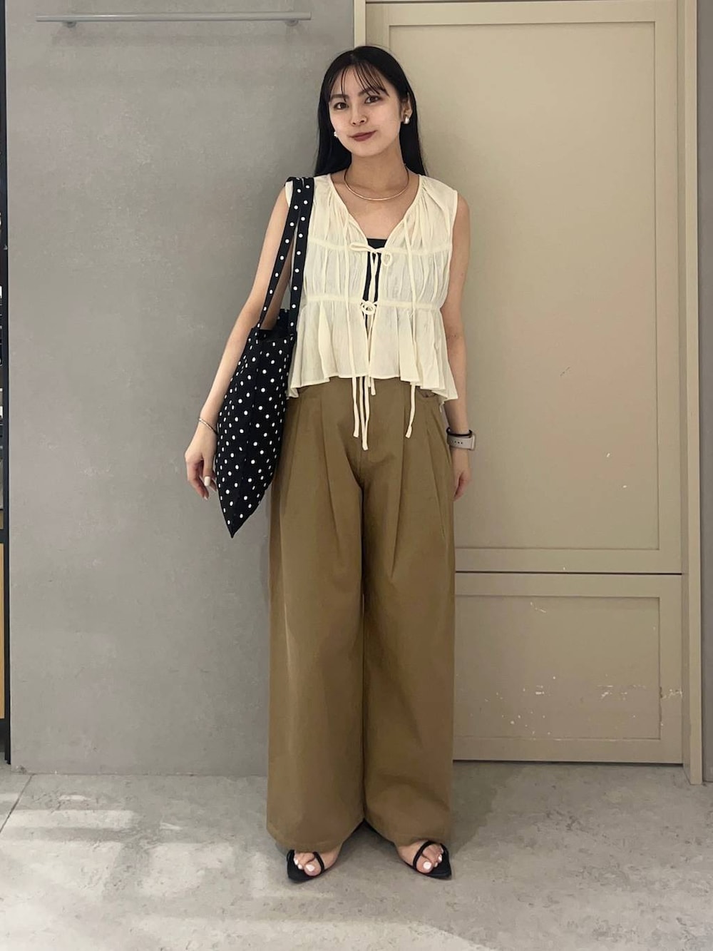 ブラック系のキャミソール、その他のトートバッグ、ブラック系のサンダルを着用したレディースの夏コーディネートの2枚目の写真