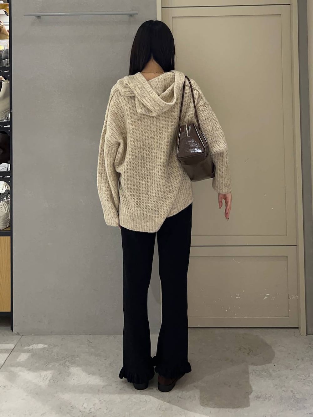 ホワイト系のニット/セーター、ブラック系のその他パンツ、ブラウン系のローファーを着用したレディースの秋コーディネートの4枚目の写真