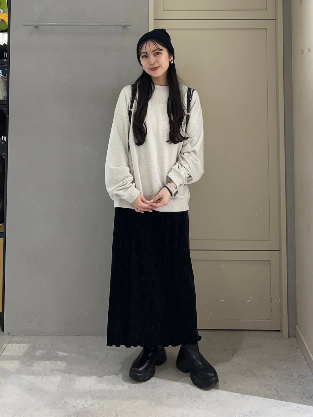 ブラック系のブーツ、ブラック系のスカート、ブラック系のショルダーバッグを着用したレディースの冬コーディネートの2枚目の写真