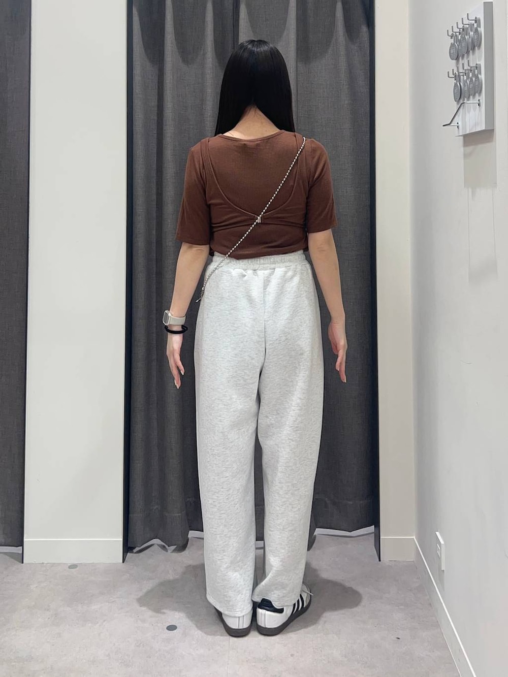 シルバー系のショルダーバッグ、グレー系のスウェットパンツ、ブラウン系のTシャツ/カットソーを着用したレディースの春コーディネートの2枚目の写真