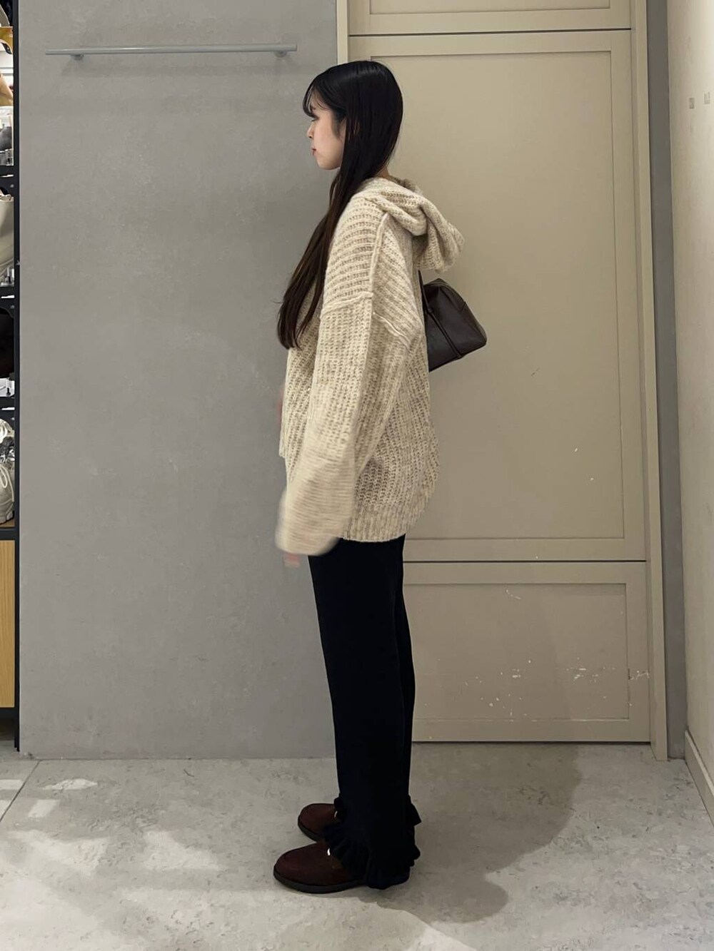 ホワイト系のニット/セーター、ブラック系のその他パンツ、ブラウン系のローファーを着用したレディースの秋コーディネートの3枚目の写真