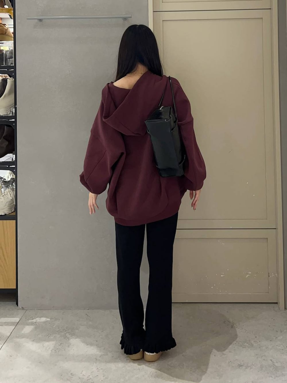 レッド系のパーカー、ブラック系のその他パンツ、ブラック系のボストンバッグを着用したレディースの秋コーディネートの4枚目の写真