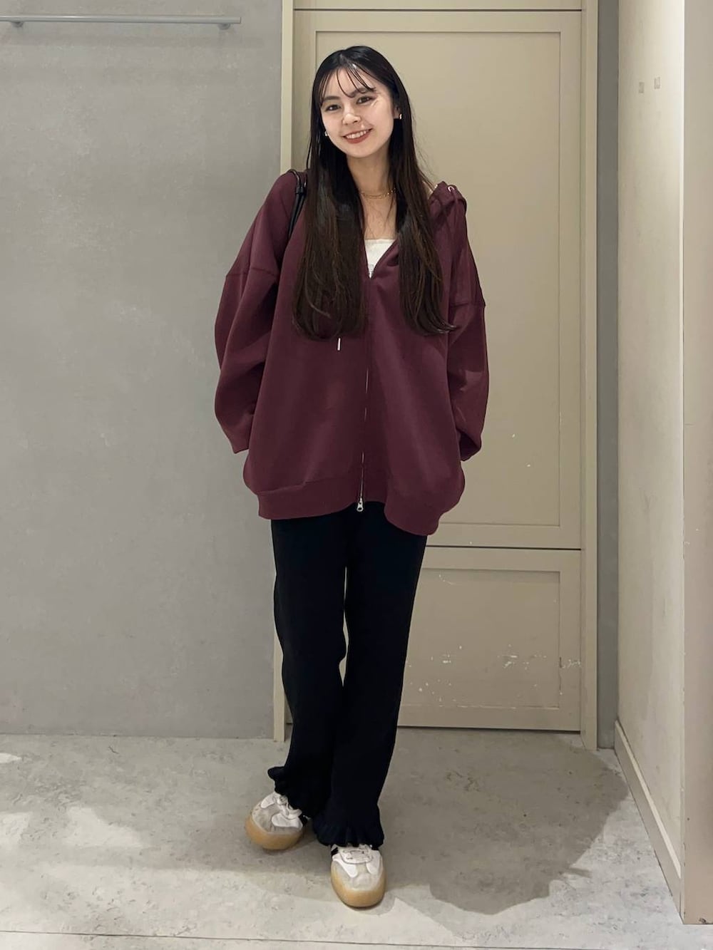 レッド系のパーカー、ブラック系のその他パンツ、ブラック系のボストンバッグを着用したレディースの秋コーディネートの2枚目の写真