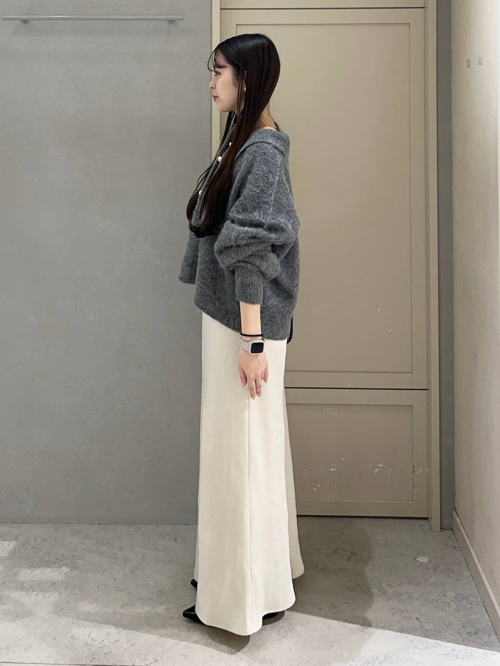 ホワイト系のスカート、ブラック系のパンプス、ブラック系のボストンバッグを着用したレディースの秋コーディネートの2枚目の写真