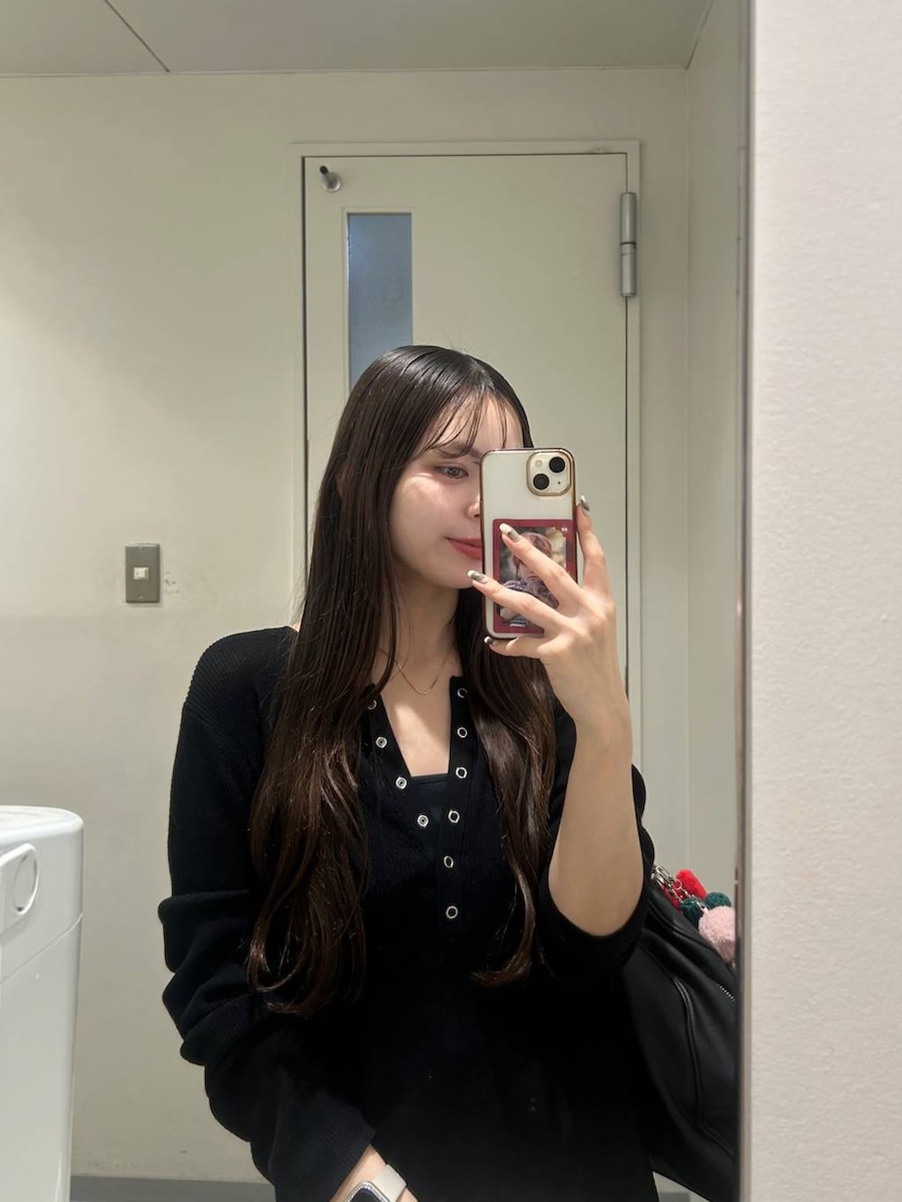 ブラック系のショルダーバッグ、ブラック系のニット/セーター、その他のネックレスを着用したレディースの秋コーディネートの2枚目の写真