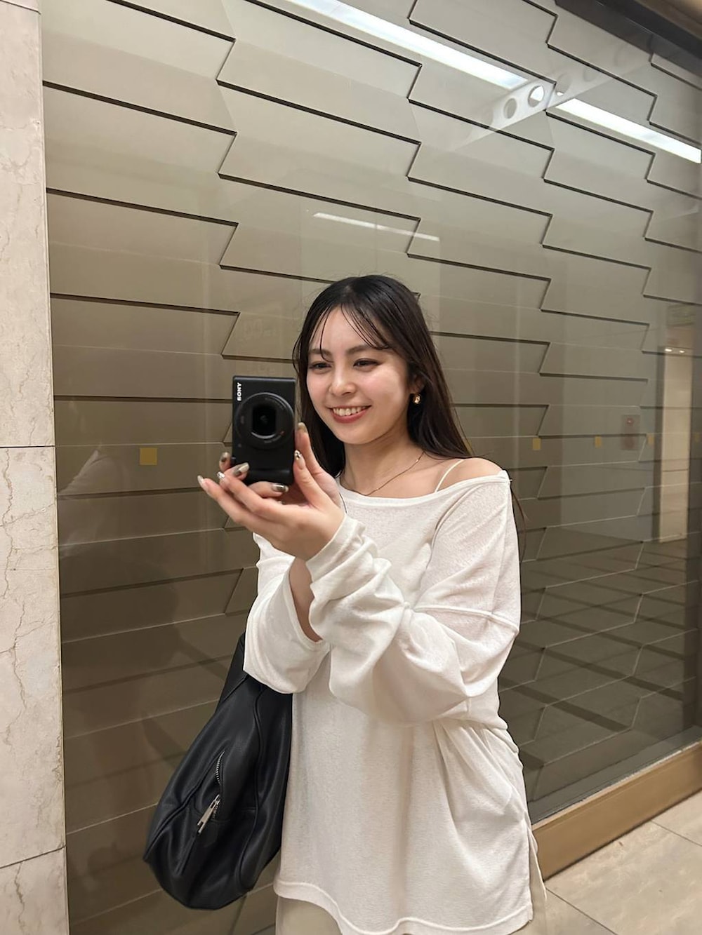 ブラック系のショルダーバッグ、ホワイト系のTシャツ/カットソー、その他のネックレスを着用したレディースの秋コーディネートの3枚目の写真