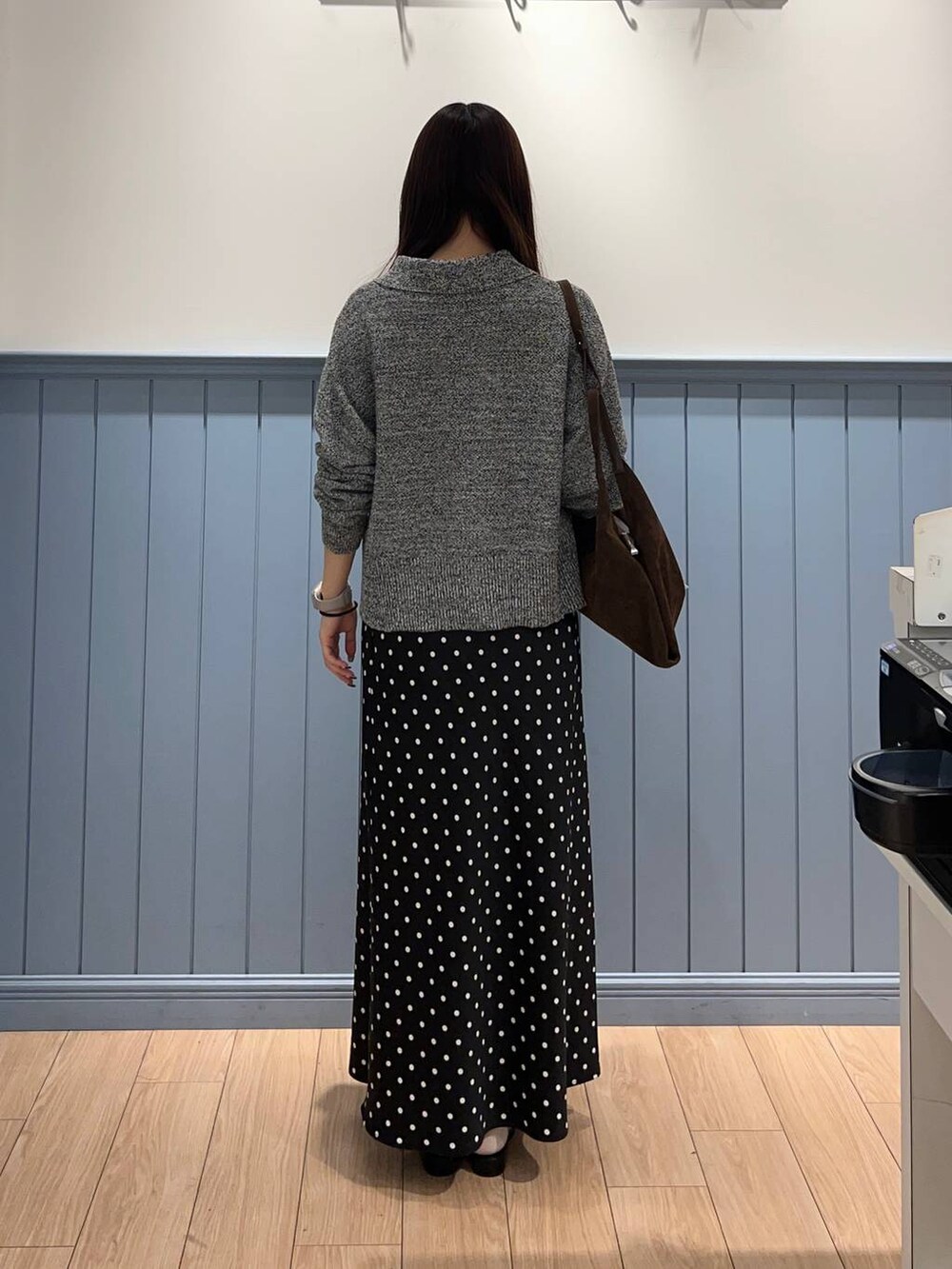 ブラック系のスカート、ブラウン系のショルダーバッグ、グレー系のカーディガン/ボレロを着用したレディースの春コーディネートの3枚目の写真