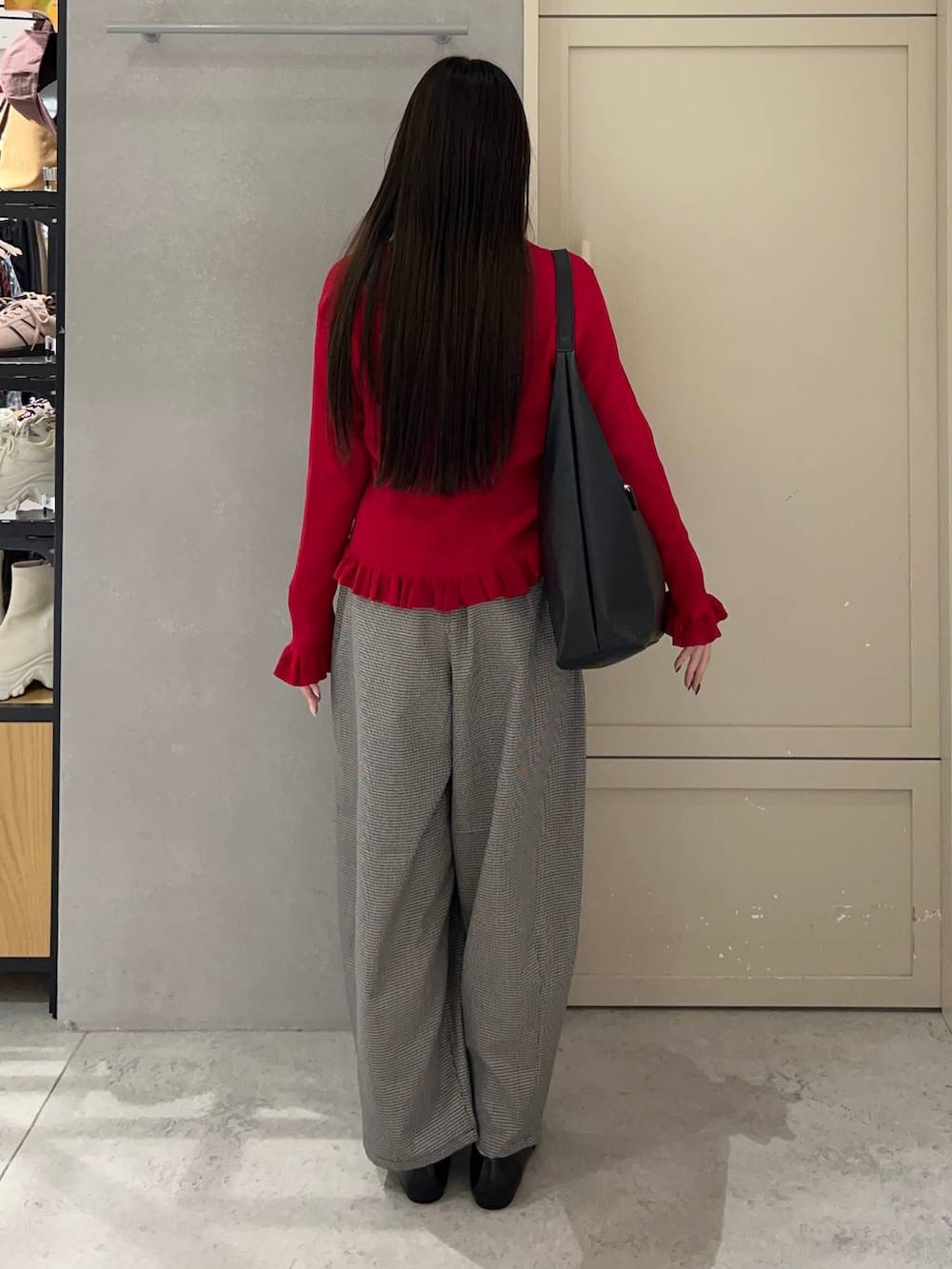 ブラック系のショルダーバッグ、ブラック系のパンプス、レッド系のニット/セーターを着用したレディースの秋コーディネートの4枚目の写真