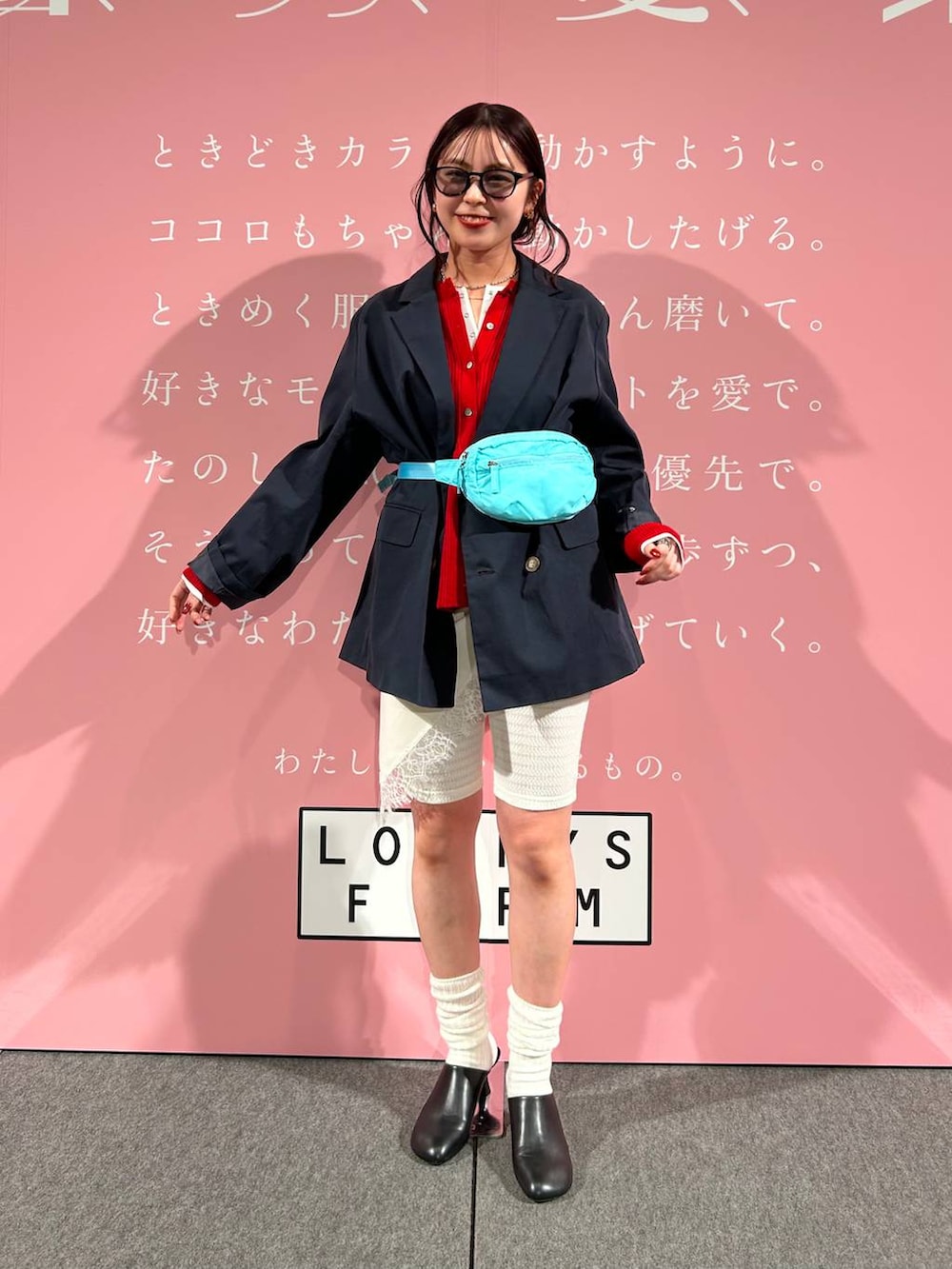 ブルー系のボディバッグ/ウエストポーチ、ブラック系のサンダル、ホワイト系のTシャツ/カットソーを着用したレディースの春コーディネートの2枚目の写真