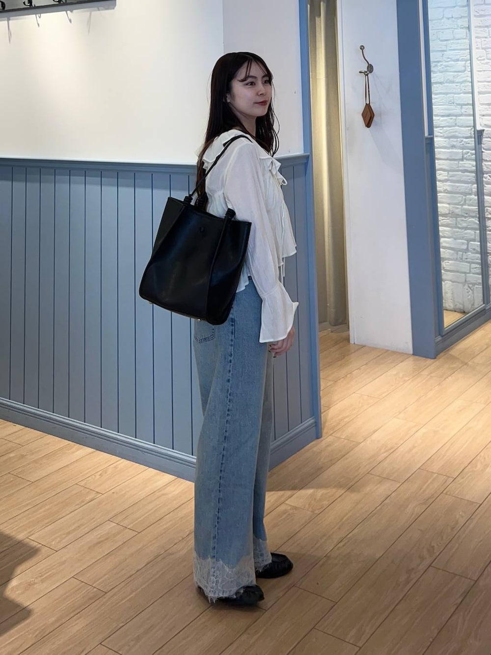 ブルー系のデニムパンツ、ブラック系のローファー、ホワイト系のシャツ/ブラウスを着用したレディースの春コーディネートの2枚目の写真