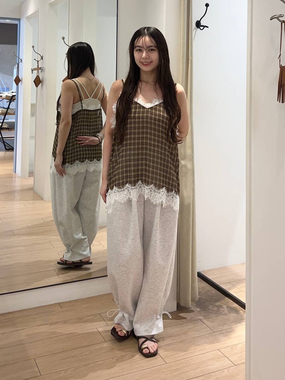 ホワイト系のTシャツ/カットソー、ブラウン系のサンダル、グレー系のスウェットパンツを着用したレディースの夏コーディネートの2枚目の写真
