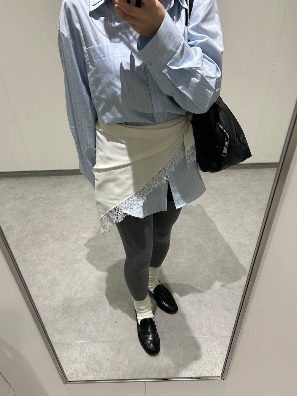 ブラック系のショルダーバッグ、ブラック系のローファー、ブルー系のシャツ/ブラウスを着用したレディースの春コーディネートの3枚目の写真