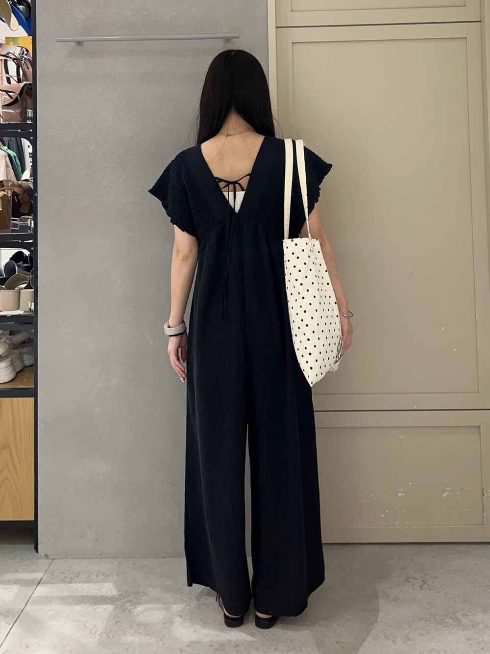 ホワイト系のキャミソール、その他のトートバッグ、ブラック系のサンダルを着用したレディースの夏コーディネートの4枚目の写真