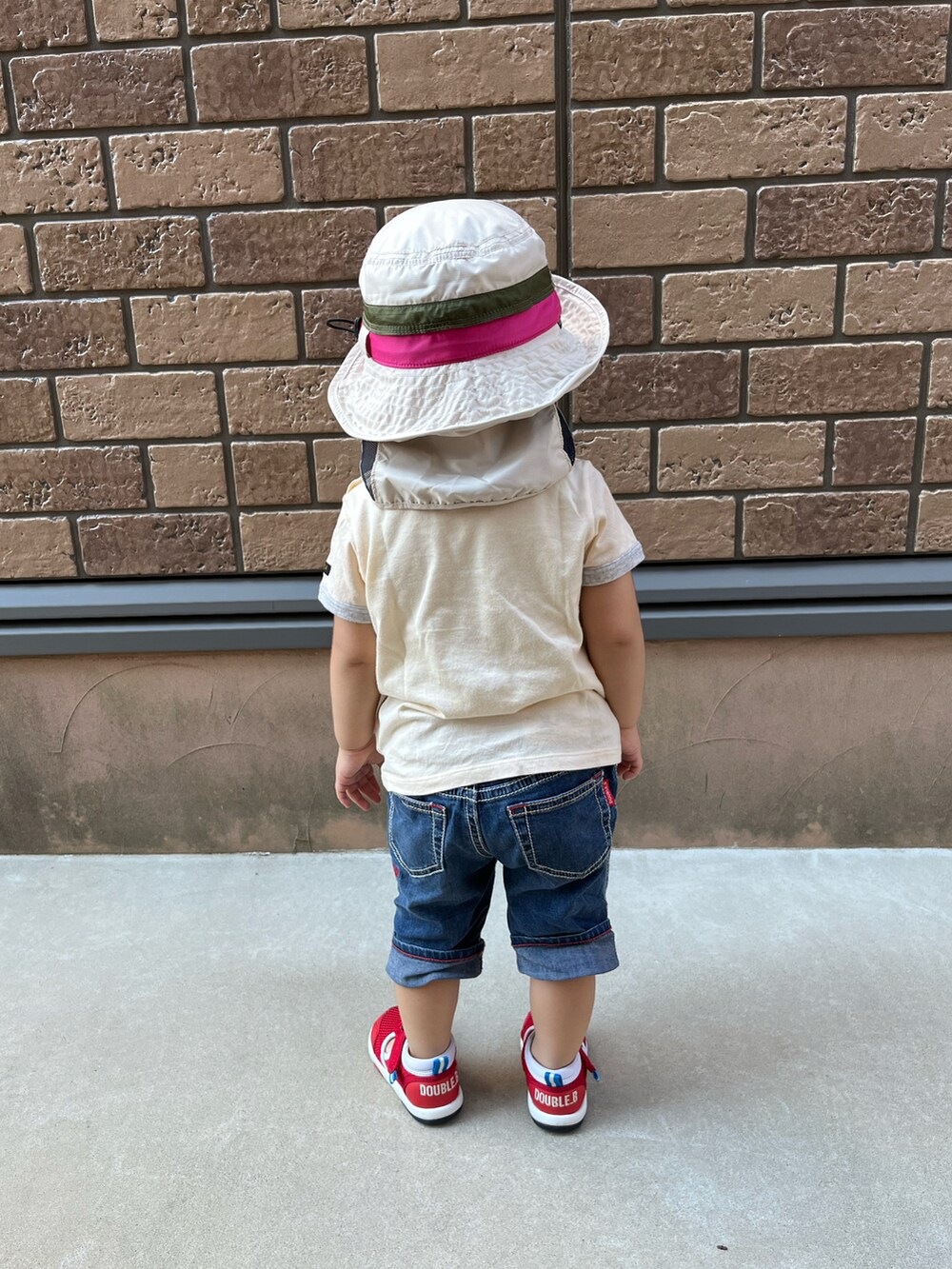 ベージュ系のTシャツ/カットソー、ブルー系のパンツ、レッド系のサンダルを着用したキッズの夏コーディネートの2枚目の写真