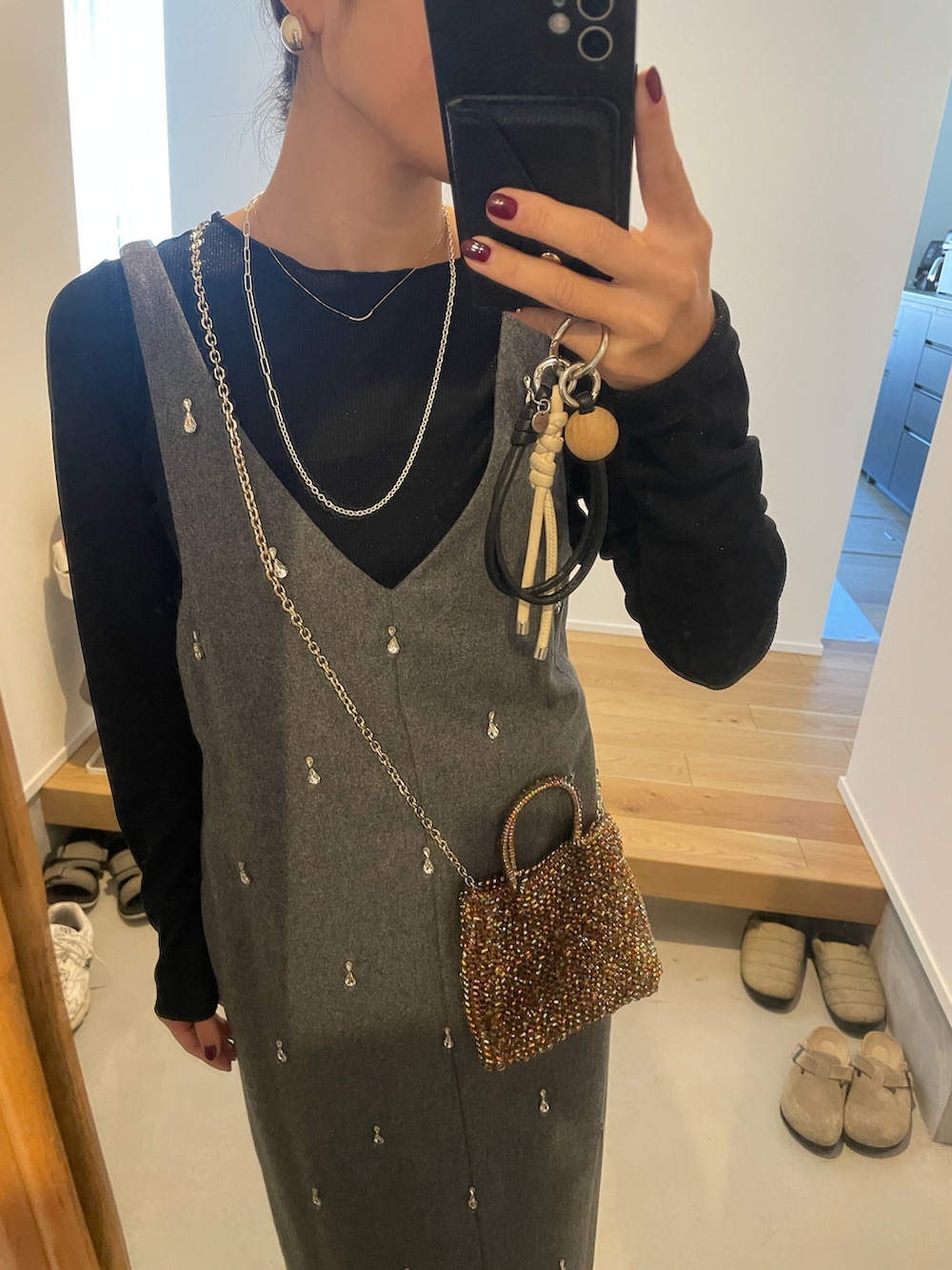 グレー系のワンピース、その他のショルダーバッグ、ベージュ系のバレエシューズを着用したレディースの冬コーディネートの2枚目の写真