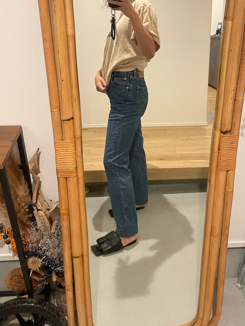 ブラック系のサンダル、ブルー系のデニムパンツを着用したレディースの秋コーディネートの2枚目の写真