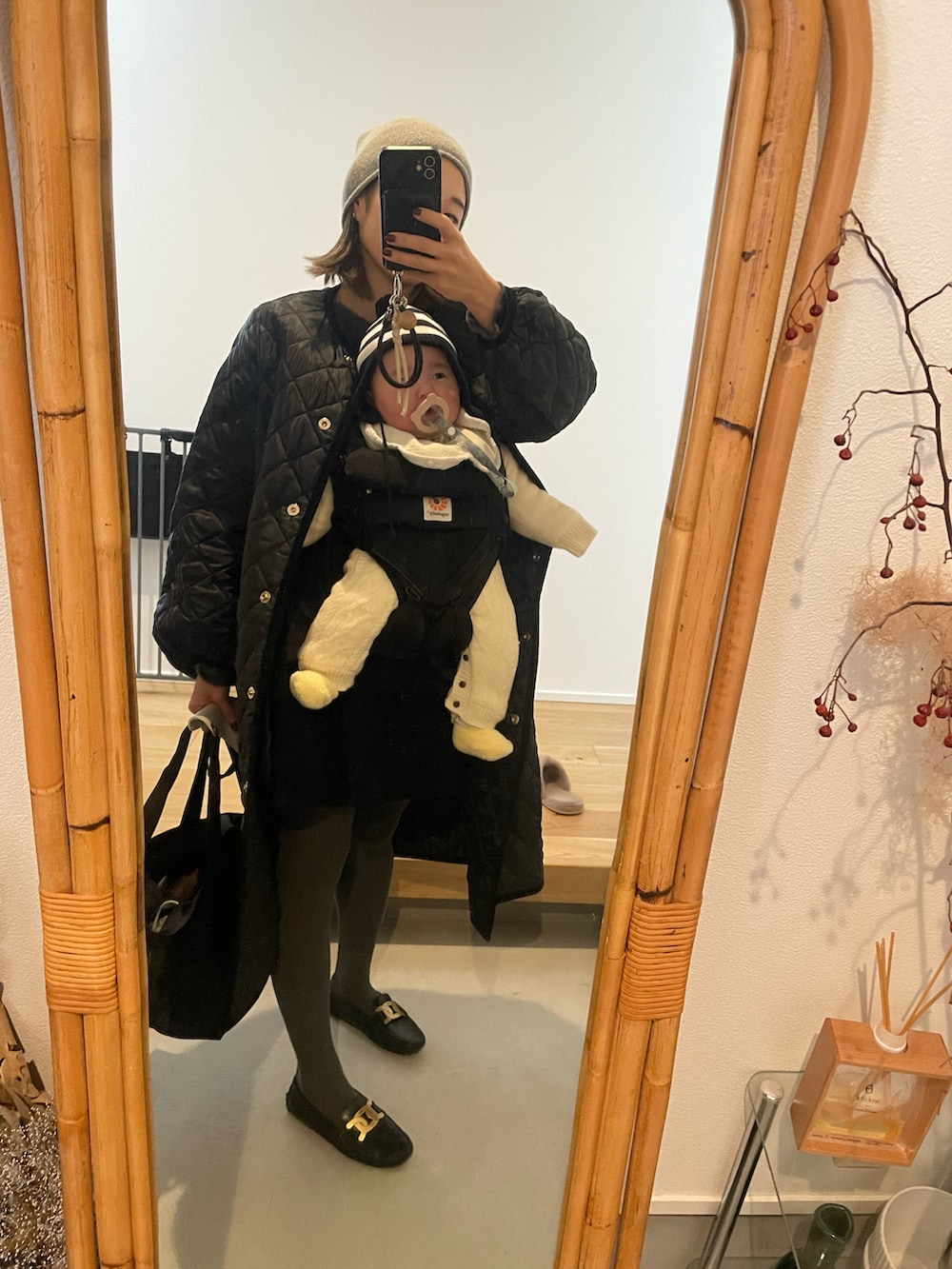 ブラック系のシューズ、ブラック系のノーカラーコートを着用したレディースの冬コーディネートの2枚目の写真