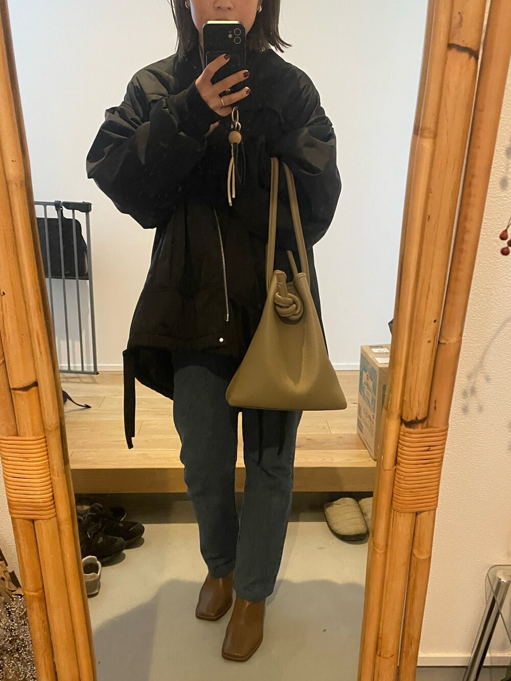 ブルー系のデニムパンツ、ブラウン系のブーツ、ブラック系のMA-1を着用したレディースの秋コーディネートの2枚目の写真