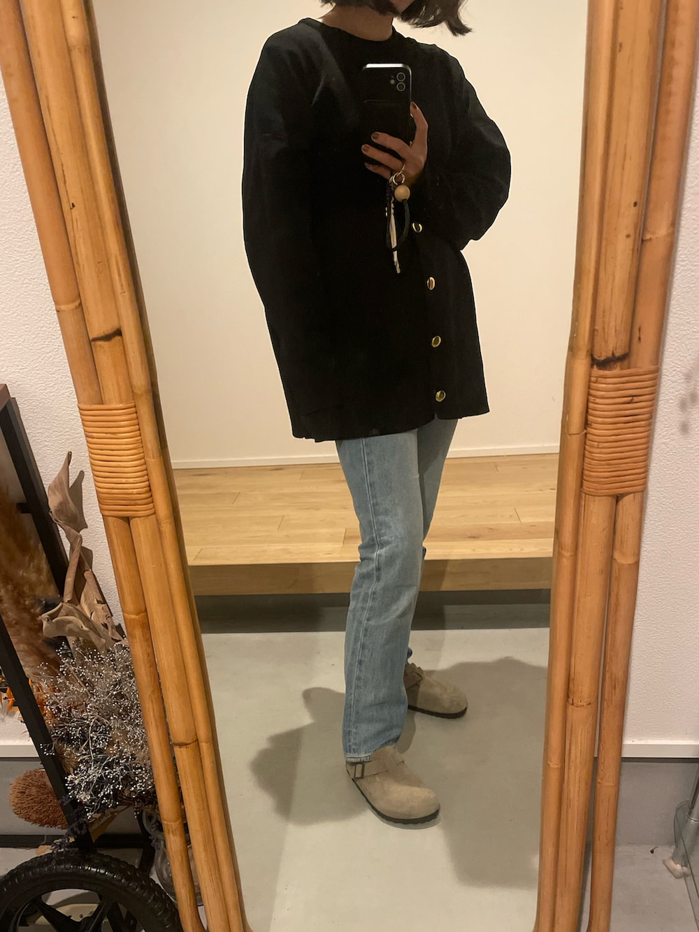 ベージュ系のサンダル、ブルー系のデニムパンツ、ブラック系のカーディガン/ボレロを着用したレディースの秋コーディネートの2枚目の写真