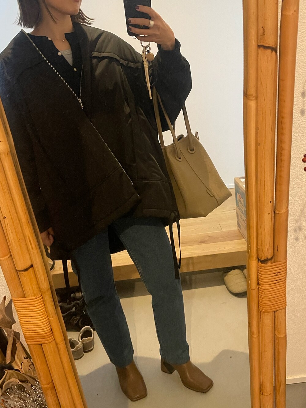 ブルー系のデニムパンツ、ブラウン系のブーツ、ブラック系のMA-1を着用したレディースの秋コーディネートの3枚目の写真