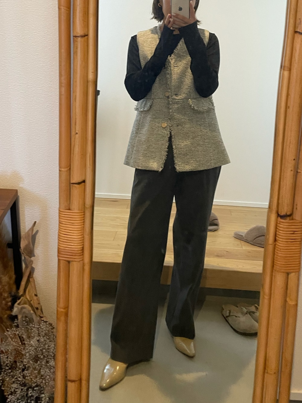 ブラック系のベスト、ベージュ系のパンプス、グレー系のスラックスを着用したレディースの冬コーディネートの2枚目の写真