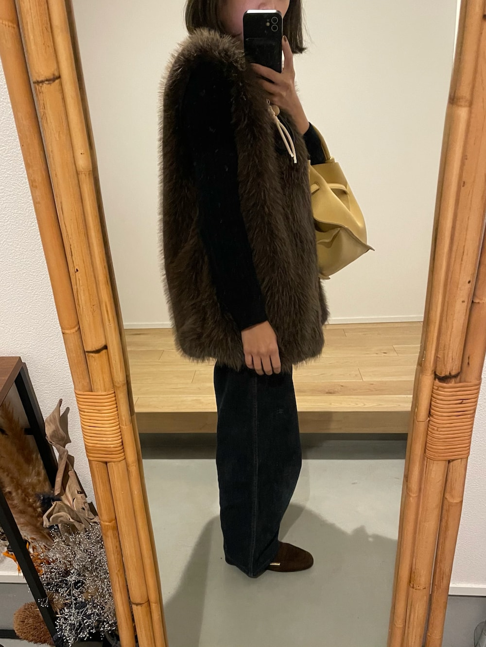 ブラック系のカーディガン/ボレロ、ブラウン系のベスト、ブラウン系のローファーを着用したレディースの秋コーディネートの3枚目の写真