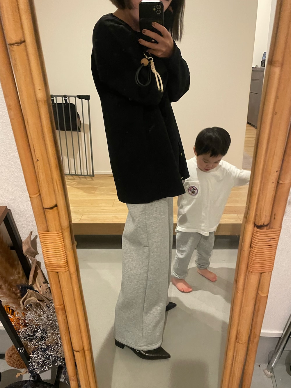 グレー系のスウェットパンツ、ブラック系のカーディガン/ボレロ、ブラック系のブーツを着用したレディースの秋コーディネートの2枚目の写真